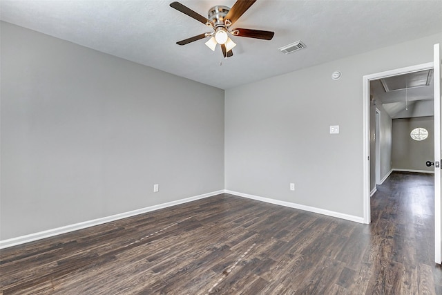 empty room featuring attic access, baseboards, visible vents, ceiling fan, and dark wood-style flooring