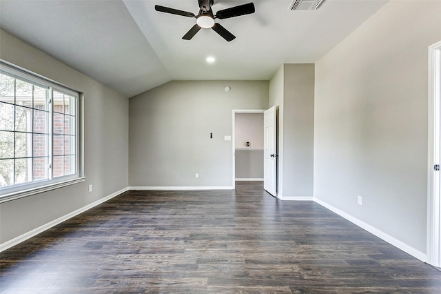 spare room featuring lofted ceiling, visible vents, baseboards, and dark wood-type flooring