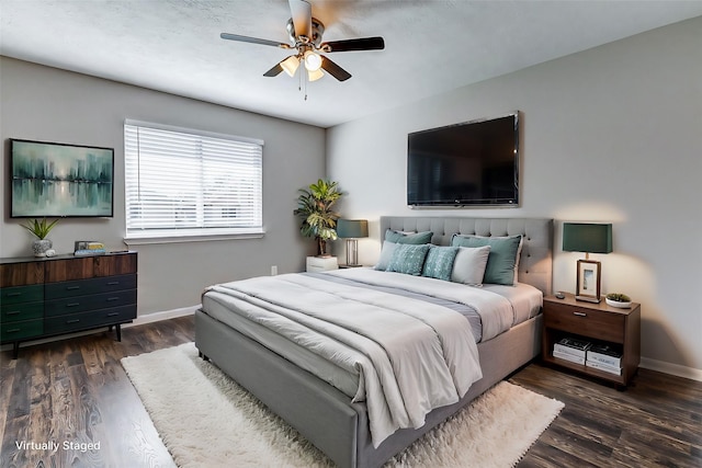 bedroom featuring dark wood-style floors, a ceiling fan, and baseboards