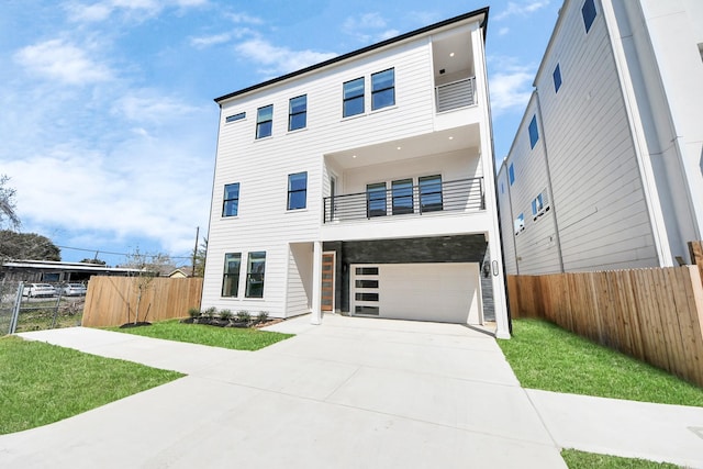 view of front of home with a balcony, a garage, fence, driveway, and a front lawn