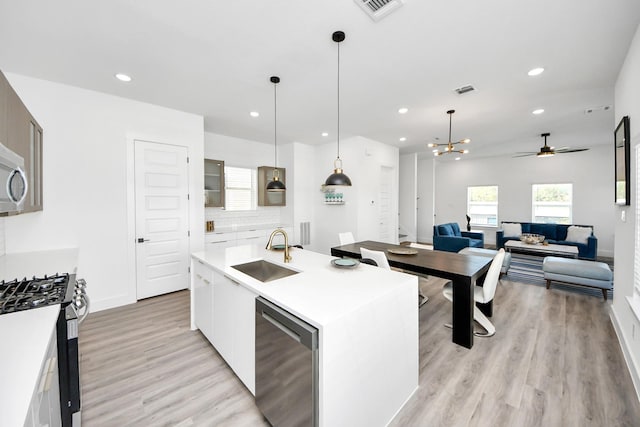 kitchen with visible vents, decorative backsplash, stainless steel appliances, light countertops, and a sink