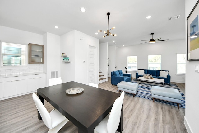 dining area with light wood-style floors, recessed lighting, visible vents, and stairway