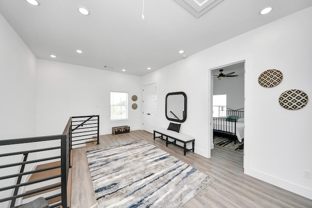 hall with recessed lighting, baseboards, wood finished floors, and an upstairs landing