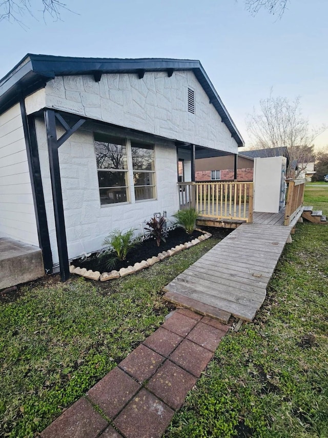 view of front of house with a front lawn and concrete block siding