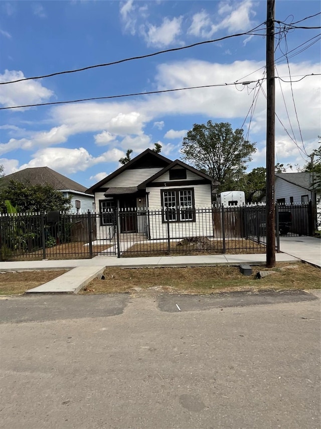 bungalow-style home with a fenced front yard and a gate