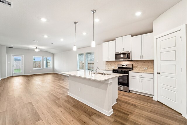 2542 Bay Winds Ln, Baytown, TX 77523 - kitchen with appliances with stainless steel finishes, a sink, tasteful backsplash, light wood-style floors, and white cabinets