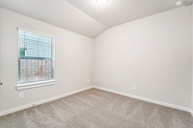 2542 Bay Winds Ln, Baytown, TX 77523 - empty room with carpet floors, vaulted ceiling, baseboards, and a smoke detector