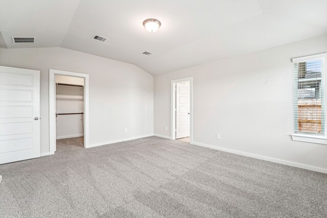 2542 Bay Winds Ln, Baytown, TX 77523 - unfurnished bedroom featuring lofted ceiling, carpet floors, baseboards, and a walk in closet