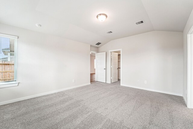 2542 Bay Winds Ln, Baytown, TX 77523 - unfurnished bedroom with lofted ceiling, carpet floors, baseboards, and a walk in closet