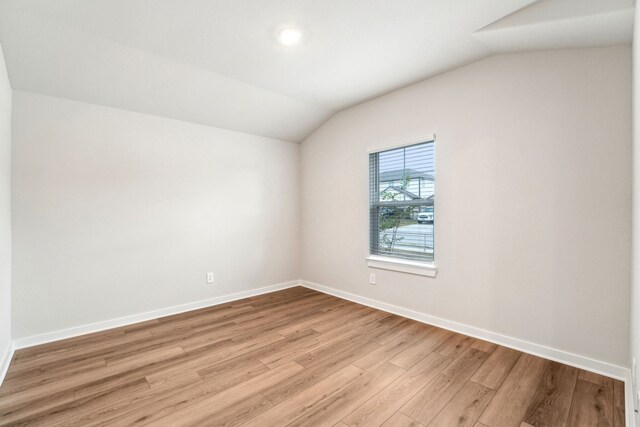 2542 Bay Winds Ln, Baytown, TX 77523 - spare room featuring lofted ceiling, light wood-type flooring, and baseboards