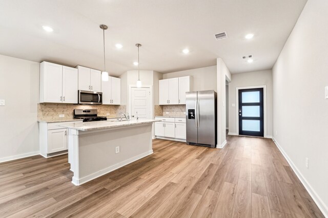 2542 Bay Winds Ln, Baytown, TX 77523 - kitchen featuring appliances with stainless steel finishes, light wood finished floors, decorative backsplash, white cabinets, and recessed lighting