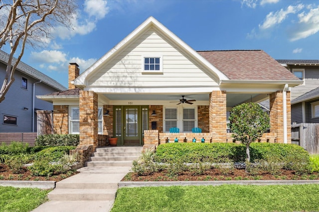 view of front of house featuring a shingled roof, a porch, a ceiling fan, and brick siding