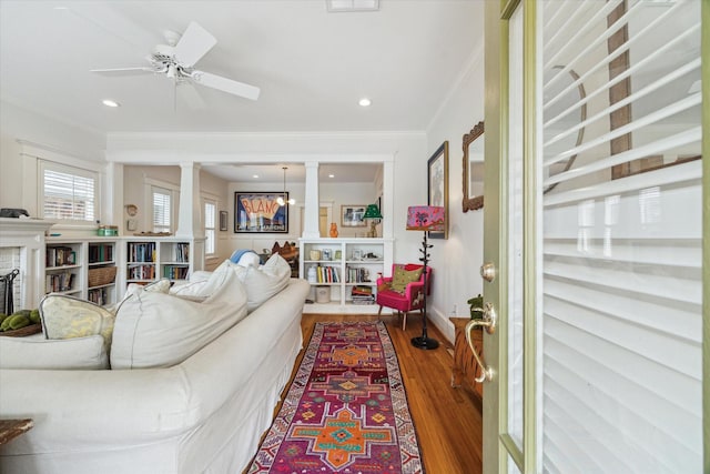 living room with ceiling fan, recessed lighting, a fireplace, wood finished floors, and crown molding