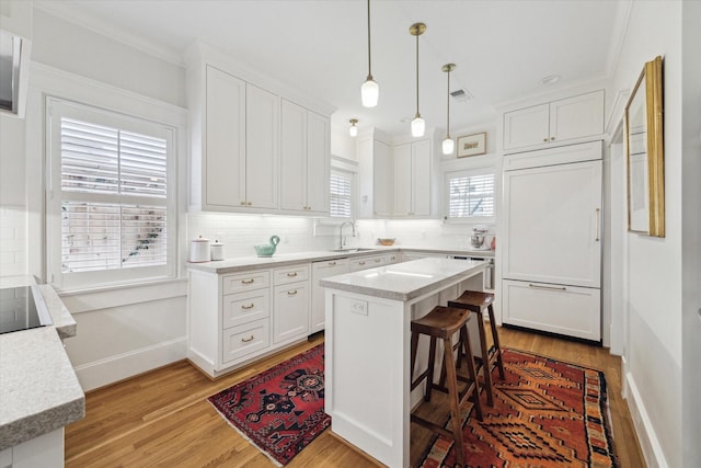 kitchen featuring white cabinetry, paneled refrigerator, and decorative backsplash