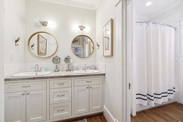 bathroom with wood finished floors, ornamental molding, and a sink