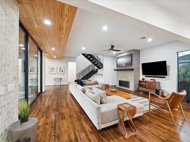 living area with stairs, a fireplace, wood finished floors, and visible vents