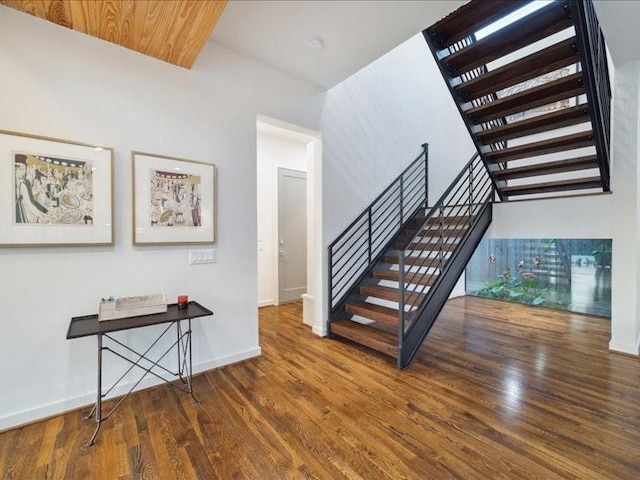 stairs with wood finished floors and baseboards