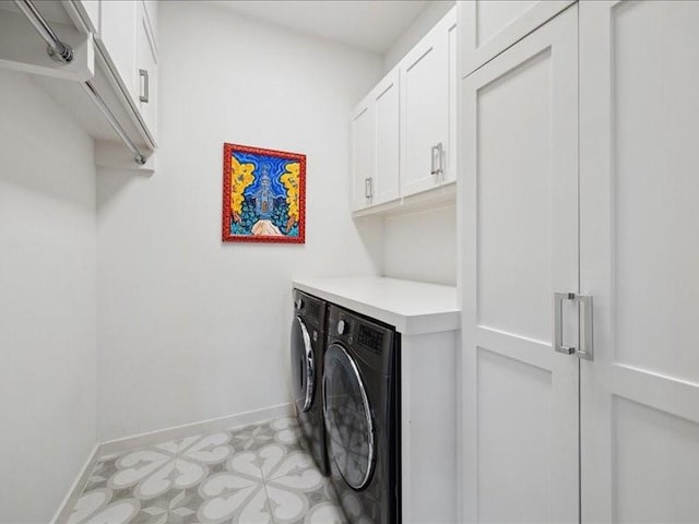 washroom with light floors, baseboards, cabinet space, and washing machine and clothes dryer