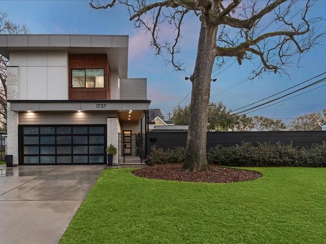 view of front facade featuring a garage, brick siding, fence, driveway, and a front yard