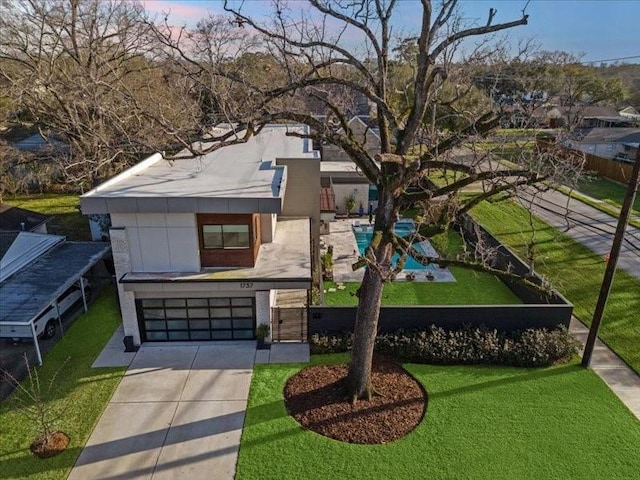 contemporary home featuring an attached garage, driveway, and a front yard