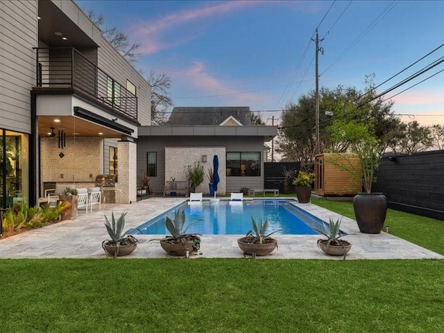 view of swimming pool with a patio area, a fenced in pool, fence, and a lawn