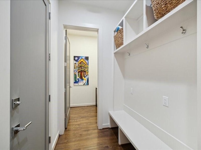 mudroom featuring dark wood-type flooring and baseboards