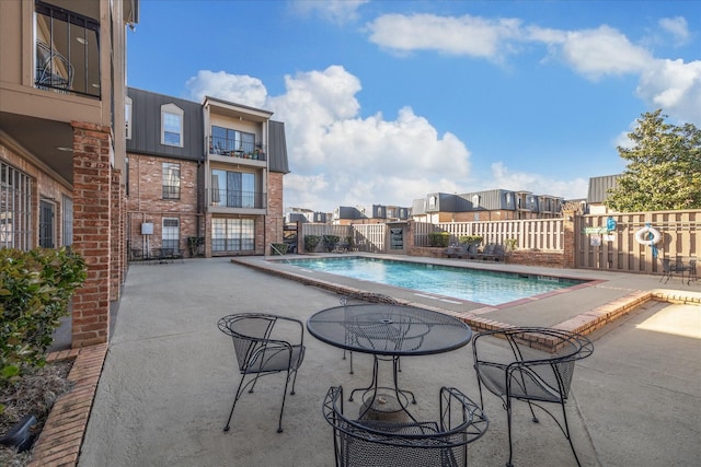 community pool with fence and a patio