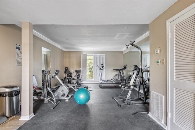 gym featuring baseboards, visible vents, and crown molding