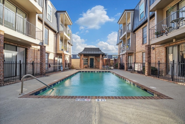 pool featuring fence and a patio