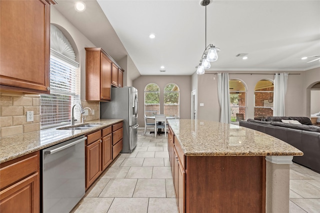 kitchen with light tile patterned floors, a kitchen island, appliances with stainless steel finishes, open floor plan, and a sink