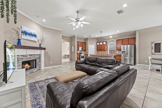 living room featuring arched walkways, crown molding, visible vents, and baseboards