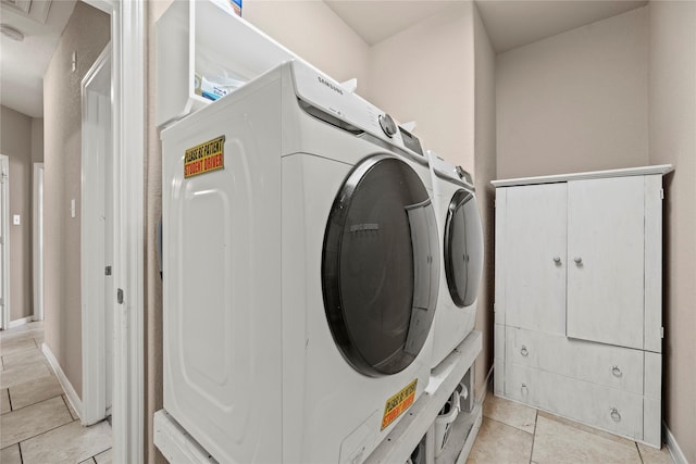 laundry room featuring laundry area, light tile patterned flooring, baseboards, and independent washer and dryer