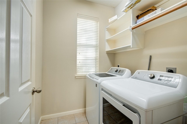 laundry area featuring laundry area, independent washer and dryer, light tile patterned flooring, and baseboards