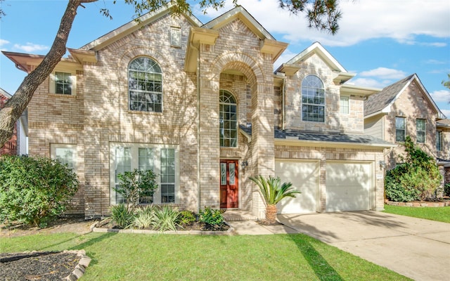 view of front of house featuring driveway, a front yard, a garage, and brick siding