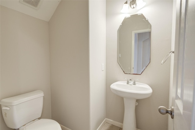 bathroom with toilet, baseboards, and visible vents