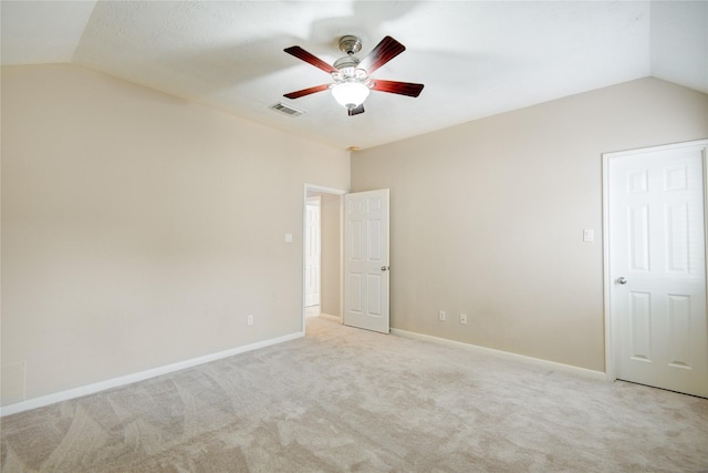 unfurnished room with lofted ceiling, light colored carpet, visible vents, ceiling fan, and baseboards