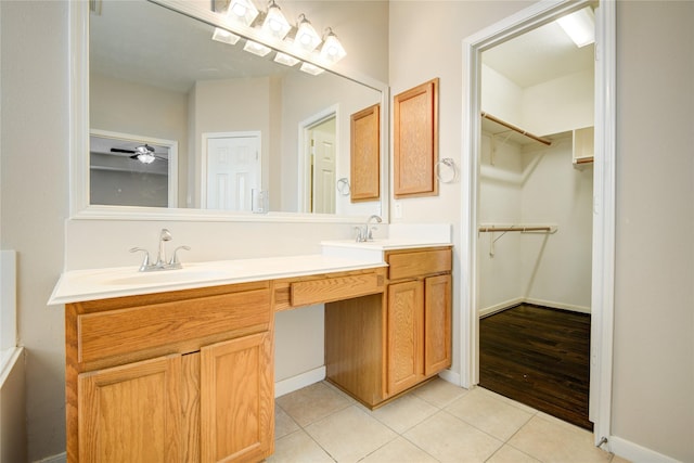 full bathroom with double vanity, tile patterned flooring, a sink, and a walk in closet