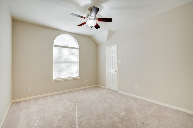 spare room featuring lofted ceiling, a ceiling fan, baseboards, and carpet flooring