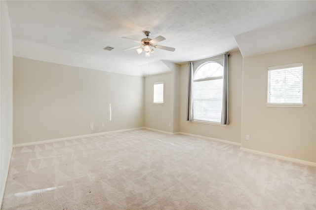 unfurnished room featuring visible vents, light colored carpet, ceiling fan, a textured ceiling, and baseboards