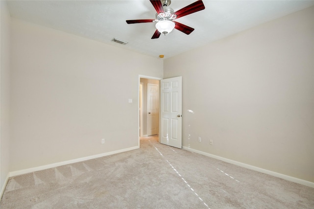 empty room featuring baseboards, visible vents, ceiling fan, and light colored carpet