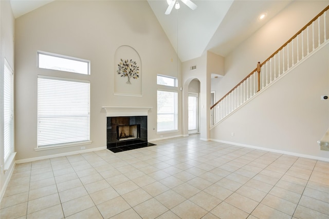 unfurnished living room with baseboards, visible vents, a tiled fireplace, and light tile patterned flooring