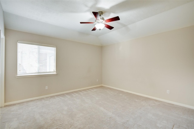 empty room with lofted ceiling, carpet, baseboards, and a ceiling fan