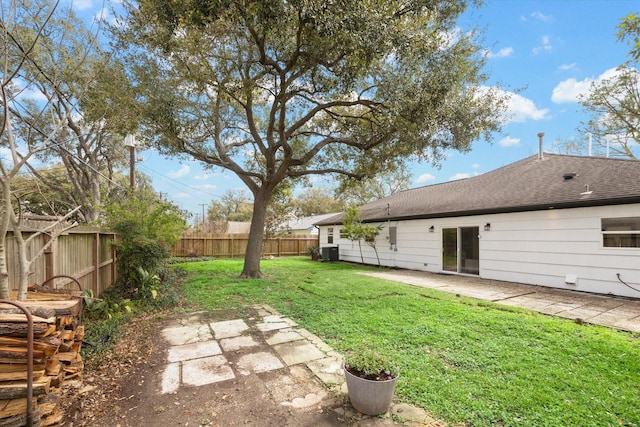 view of yard featuring a fenced backyard, central AC, and a patio