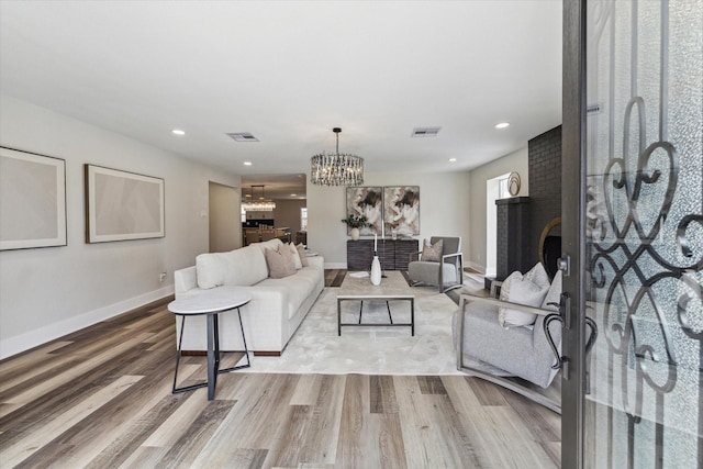 living area featuring recessed lighting, wood finished floors, visible vents, and a notable chandelier