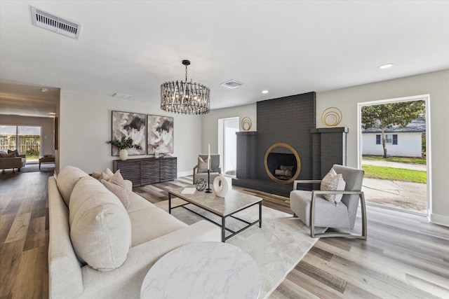 living area with light wood-style floors, recessed lighting, and visible vents