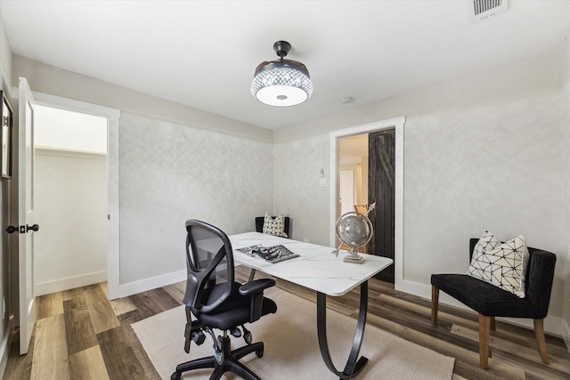 office space featuring wood finished floors, visible vents, and baseboards