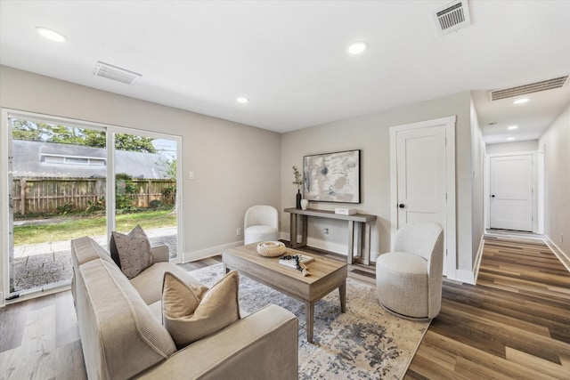 living area featuring visible vents, baseboards, and wood finished floors