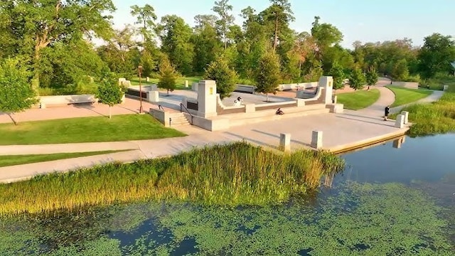 view of community featuring a water view and a yard