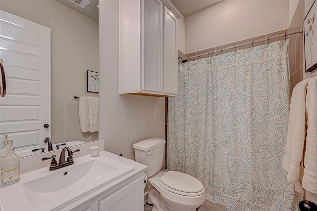 bathroom featuring toilet, visible vents, a shower with shower curtain, and vanity