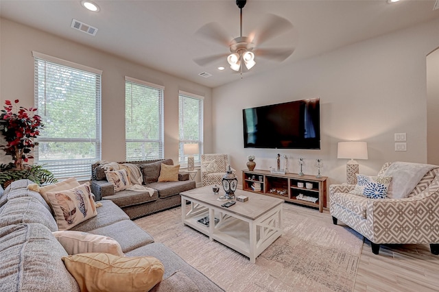 living room with light wood-style floors, visible vents, and recessed lighting